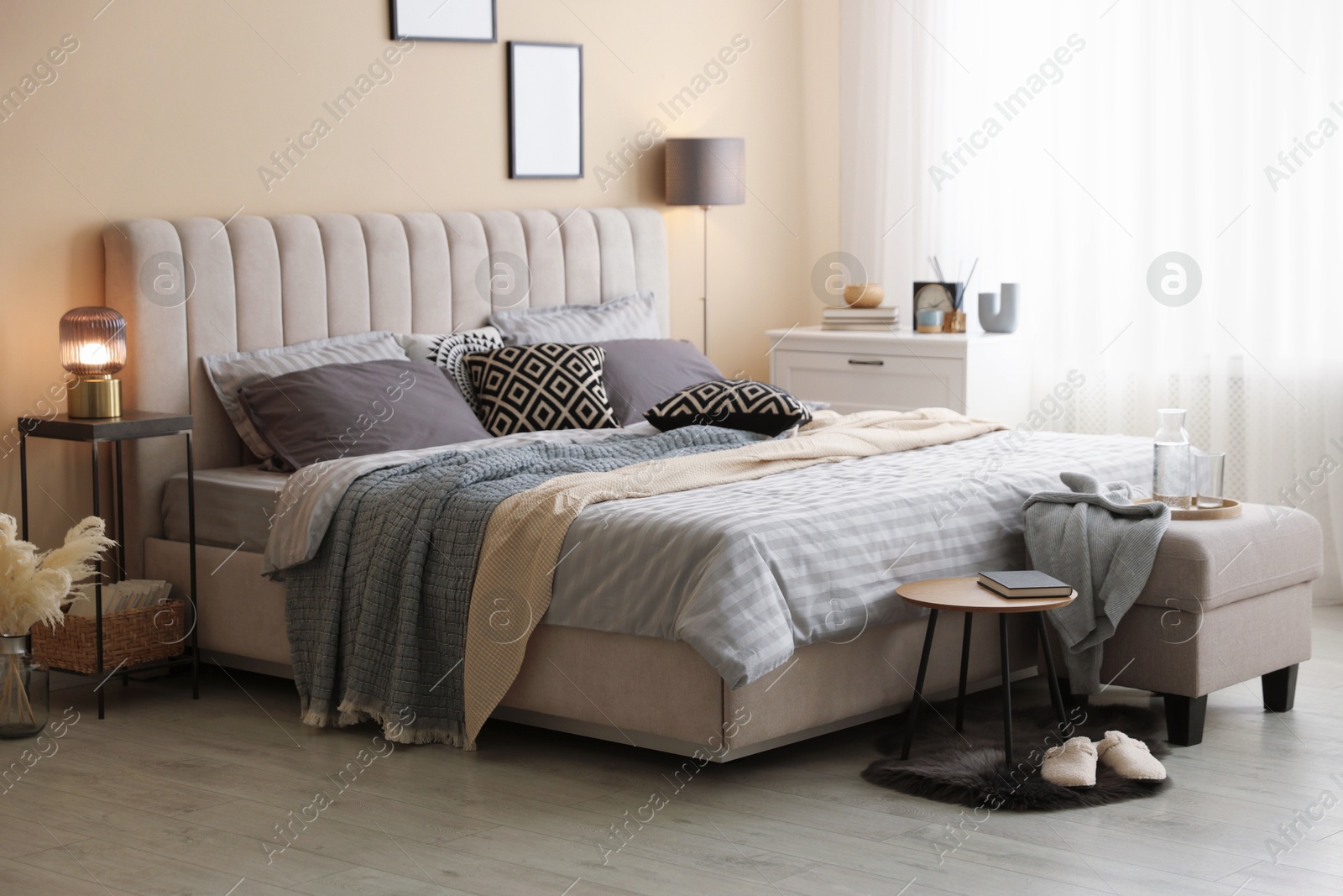 Comfortable bed with soft linens and blankets in room. Home textile Photo of Comfortable bed with soft linens and blankets in room. Home textile
