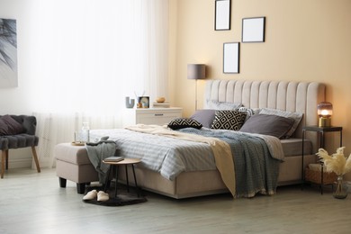 Photo of Comfortable bed with soft linens and blankets in room. Home textile