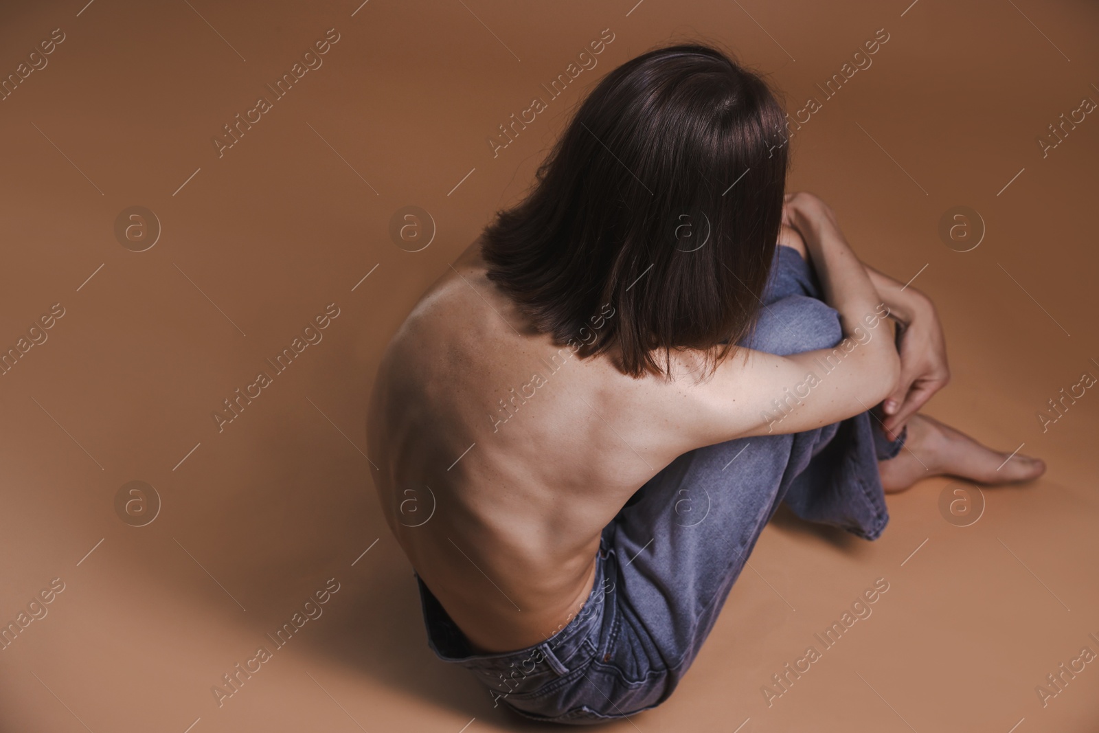 Woman suffering from anorexia on dark beige background Photo of Woman suffering from anorexia on dark beige background