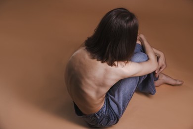 Photo of Woman suffering from anorexia on dark beige background