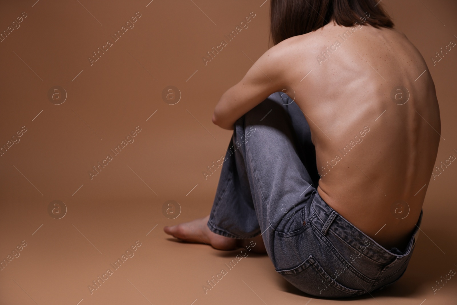 Woman suffering from anorexia on dark beige background, closeup. Space for text Photo of Woman suffering from anorexia on dark beige background, closeup. Space for text