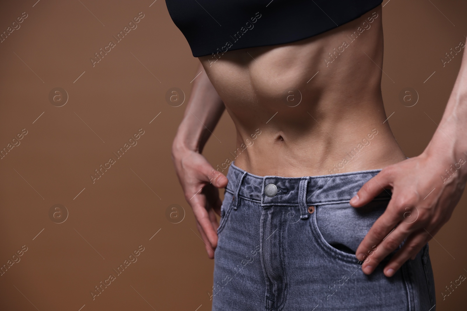 Woman suffering from anorexia on brown background, closeup. Space for text Photo of Woman suffering from anorexia on brown background, closeup. Space for text