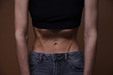 Photo of Woman suffering from anorexia on brown background, closeup