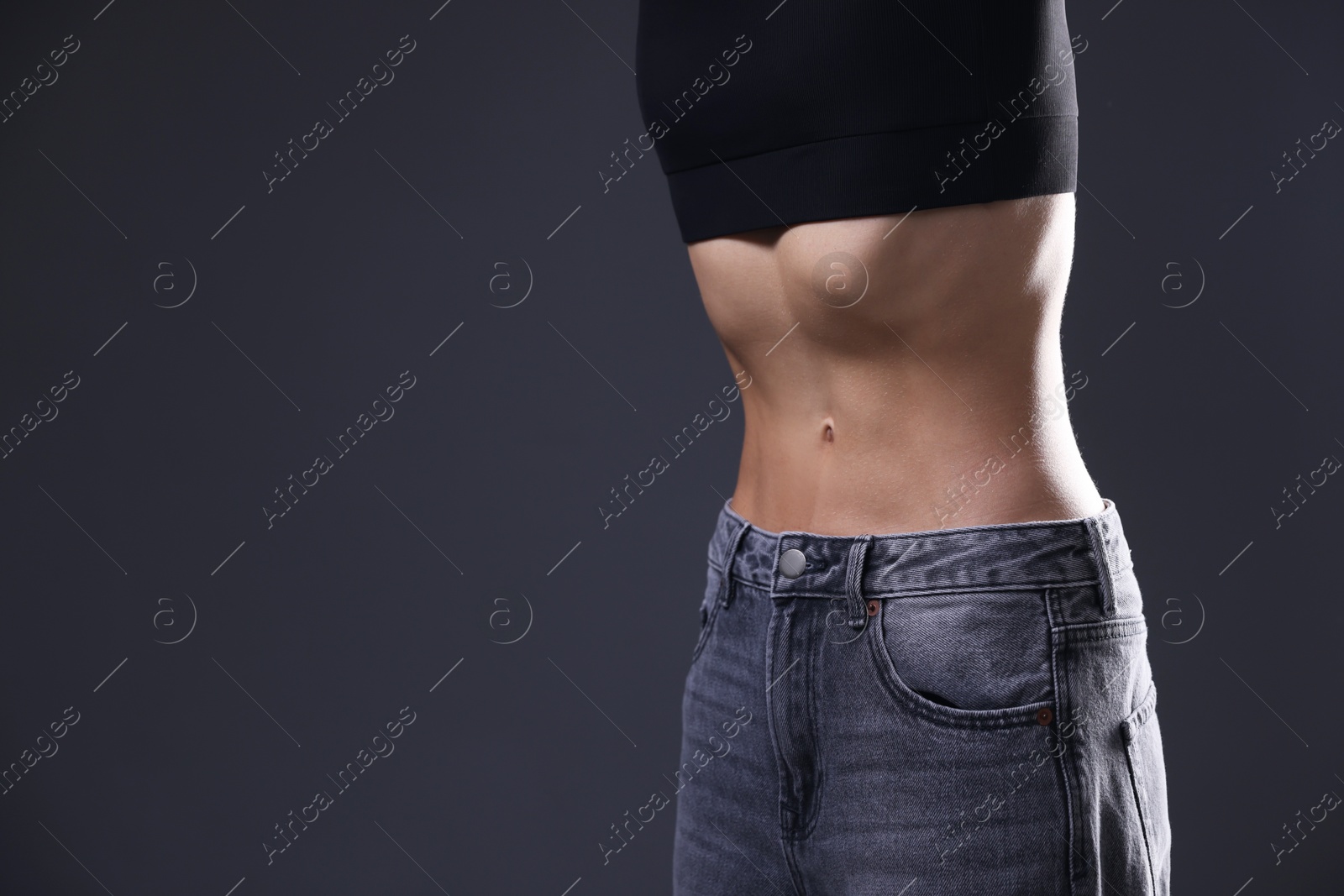 Photo of Woman suffering from anorexia on grey background, closeup. Space for text