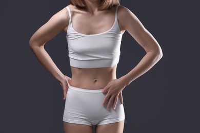 Photo of Woman suffering from anorexia on grey background, closeup
