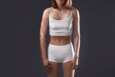 Photo of Woman suffering from anorexia on grey background, closeup