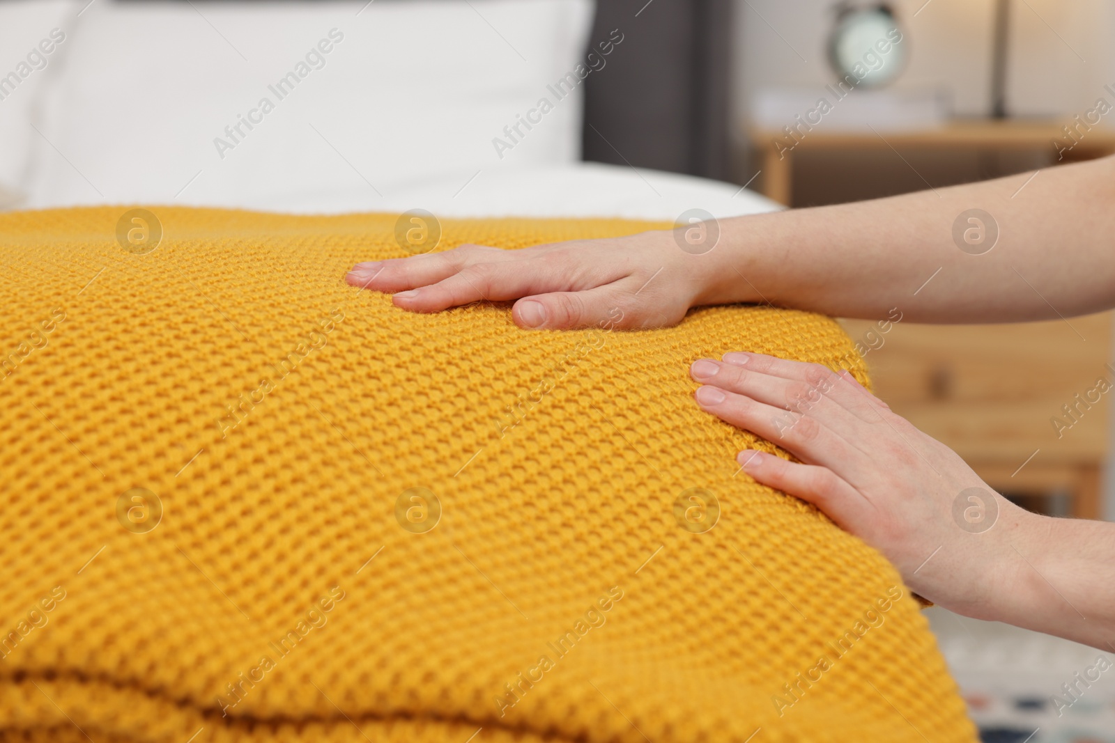 Woman folding woolen blanket at home, closeup Photo of Woman folding woolen blanket at home, closeup