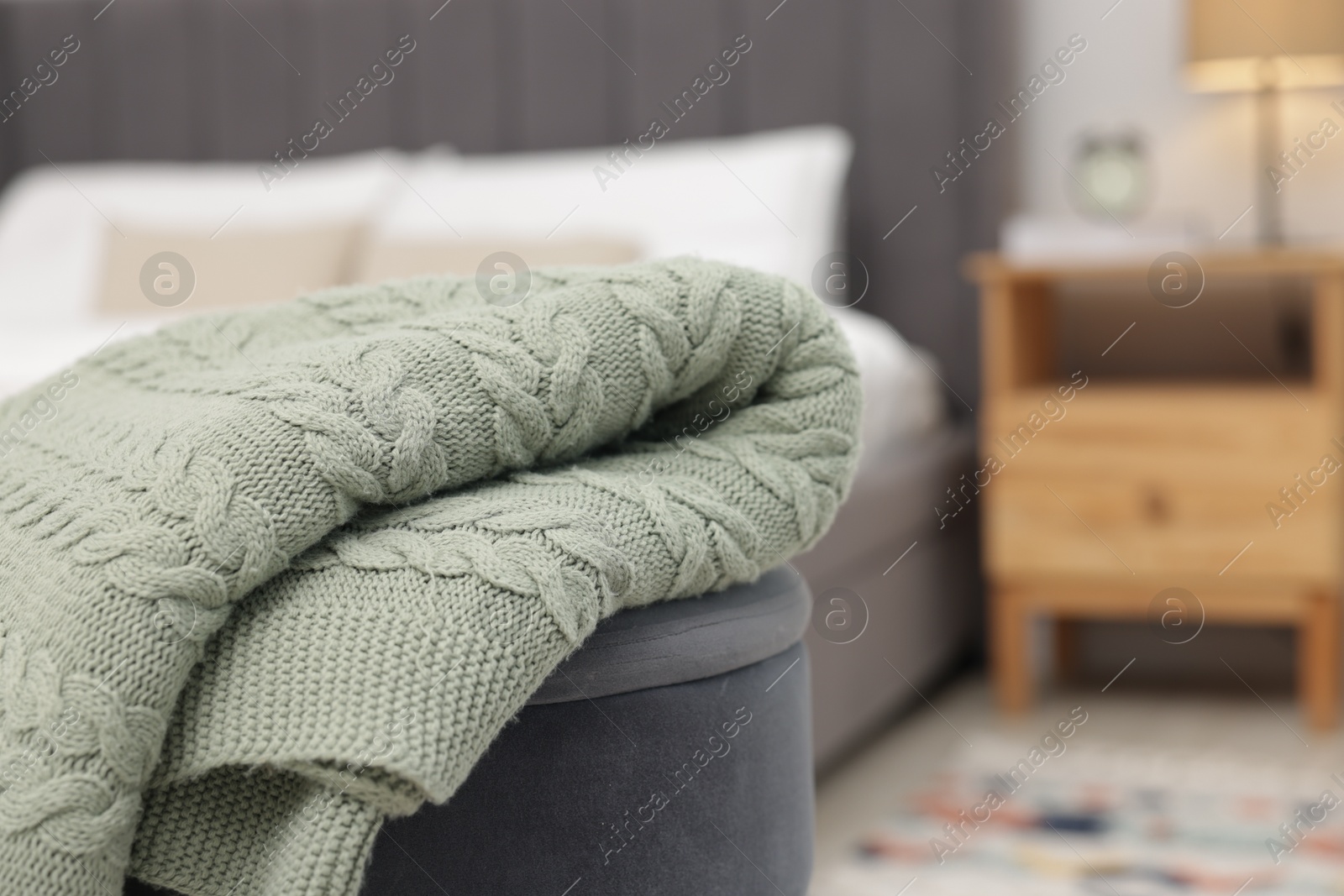Woolen blanket on pouf indoors, closeup. Space for text Photo of Woolen blanket on pouf indoors, closeup. Space for text