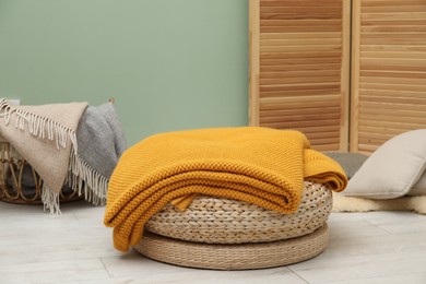 Photo of Different color woolen blankets and pillows indoors