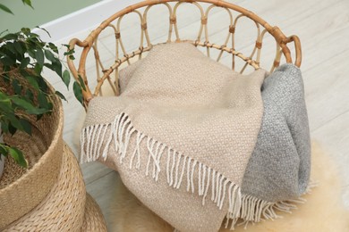 Photo of Woolen blankets in basket on floor indoors, above view