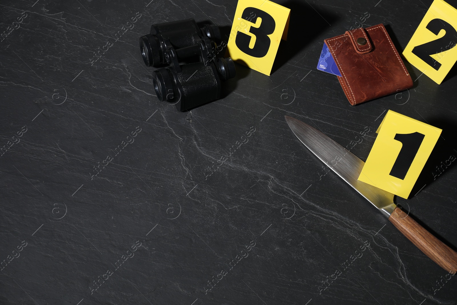 Forensic expert. Yellow evidence markers, knife, binoculars and wallet on black table, above view. Space for text Photo of Forensic expert. Yellow evidence markers, knife, binoculars and wallet on black table, above view. Space for text