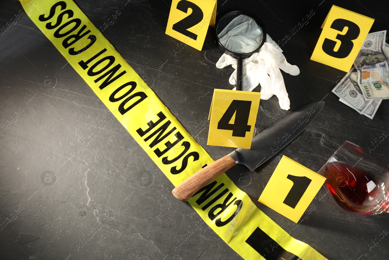 Forensic expert. Yellow crime scene tape, markers and evidences on black table, above view. Space for text Photo of Forensic expert. Yellow crime scene tape, markers and evidences on black table, above view. Space for text