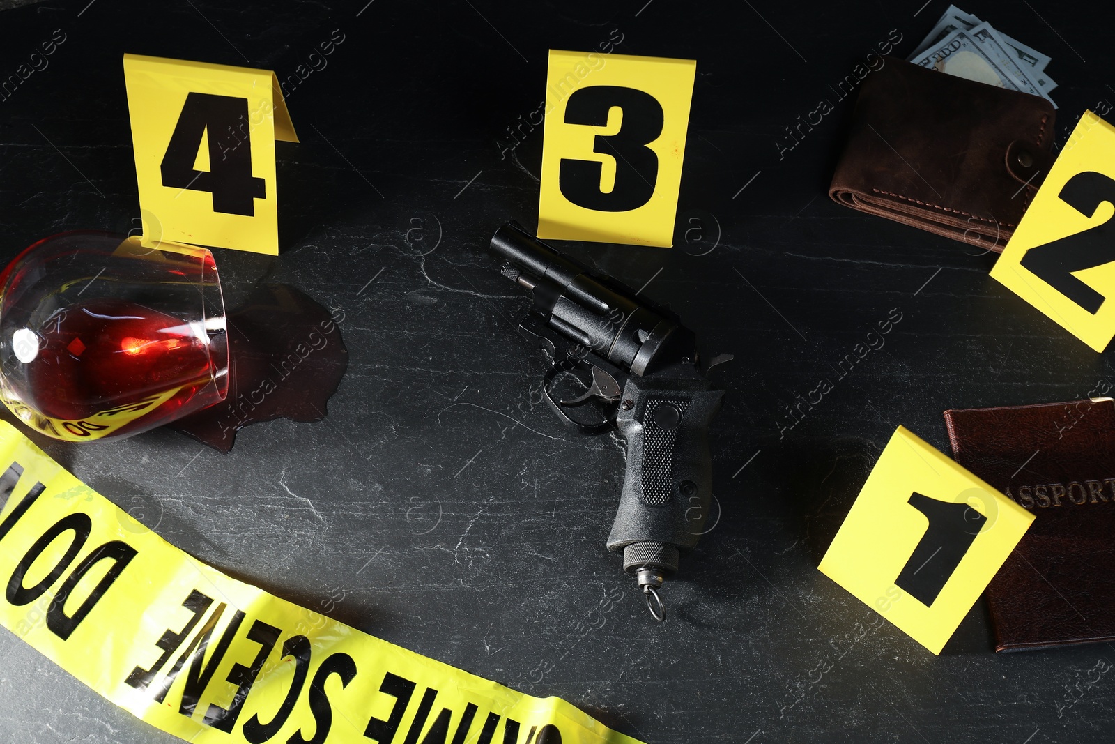 Forensic expert. Yellow crime scene tape, markers and evidences on black table, above view Photo of Forensic expert. Yellow crime scene tape, markers and evidences on black table, above view