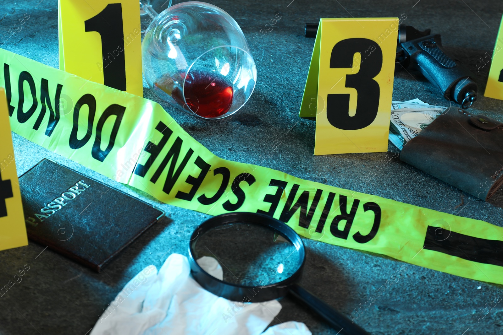 Forensic expert. Yellow crime scene tape, markers and evidences on grey table, closeup Photo of Forensic expert. Yellow crime scene tape, markers and evidences on grey table, closeup