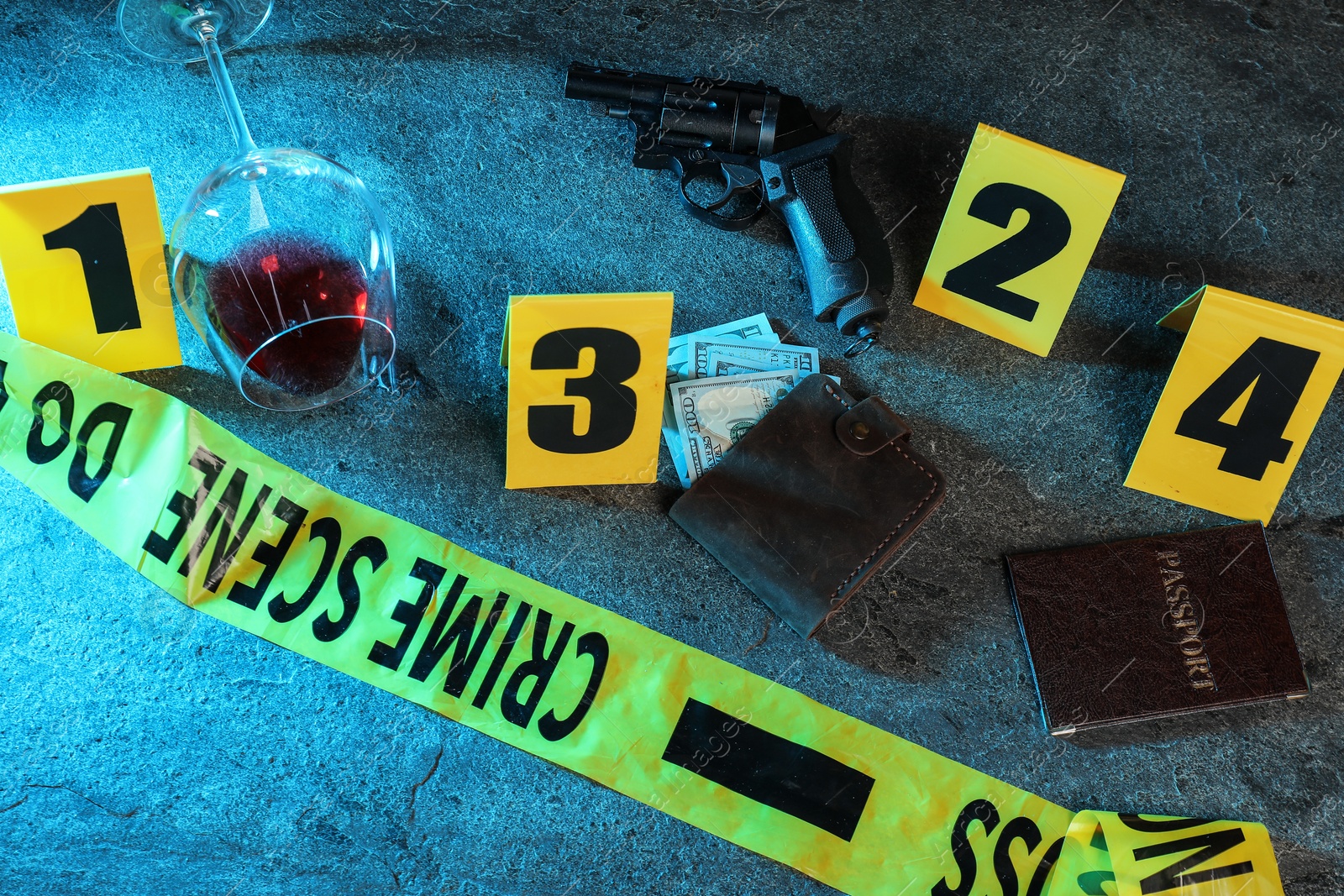 Forensic expert. Yellow crime scene tape, markers and evidences on grey table, above view Photo of Forensic expert. Yellow crime scene tape, markers and evidences on grey table, above view