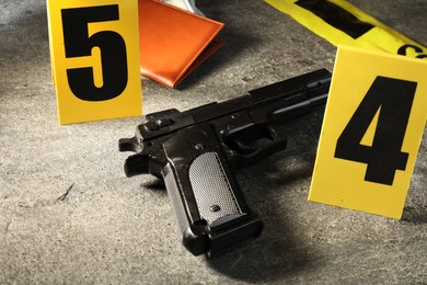 Photo of Forensic expert. Yellow crime scene tape, gun and passport on grey table, closeup