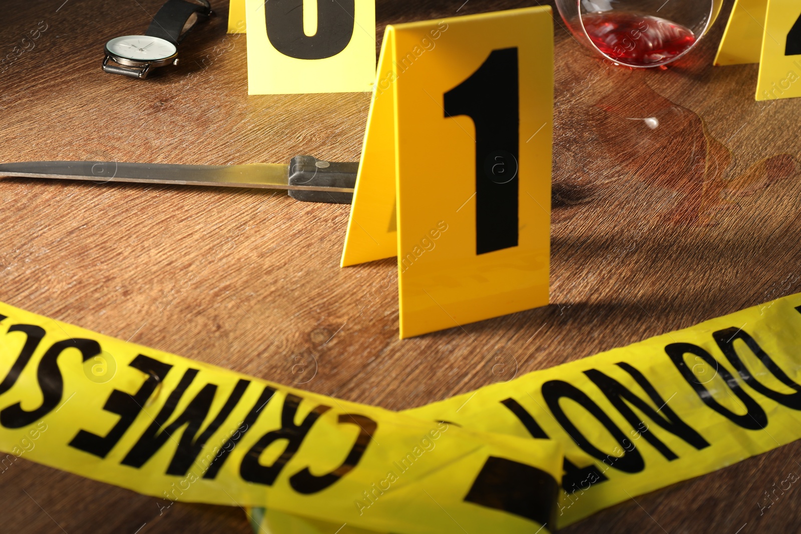 Forensic expert. Yellow crime scene tape, markers and evidences on wooden table, closeup Photo of Forensic expert. Yellow crime scene tape, markers and evidences on wooden table, closeup