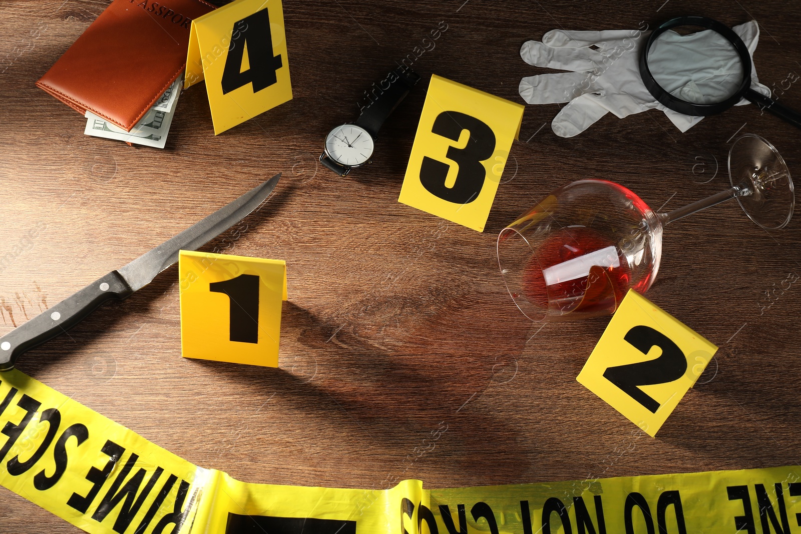 Forensic expert. Yellow crime scene tape, markers and evidences on wooden table, above view Photo of Forensic expert. Yellow crime scene tape, markers and evidences on wooden table, above view