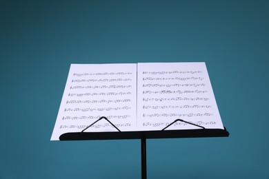 Photo of Note stand with music sheets on light blue background
