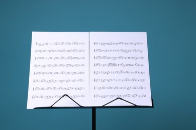 Photo of Note stand with music sheets on light blue background