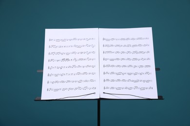 Photo of Note stand with music sheets on light blue background