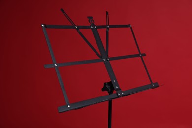 Photo of One empty note stand on red background, closeup