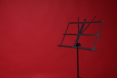 Photo of One empty note stand on red background, space for text