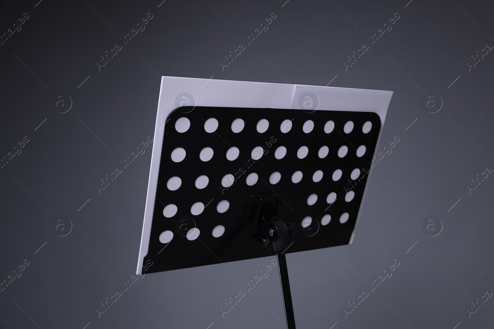 Note stand with music sheets on grey background, closeup Photo of Note stand with music sheets on grey background, closeup