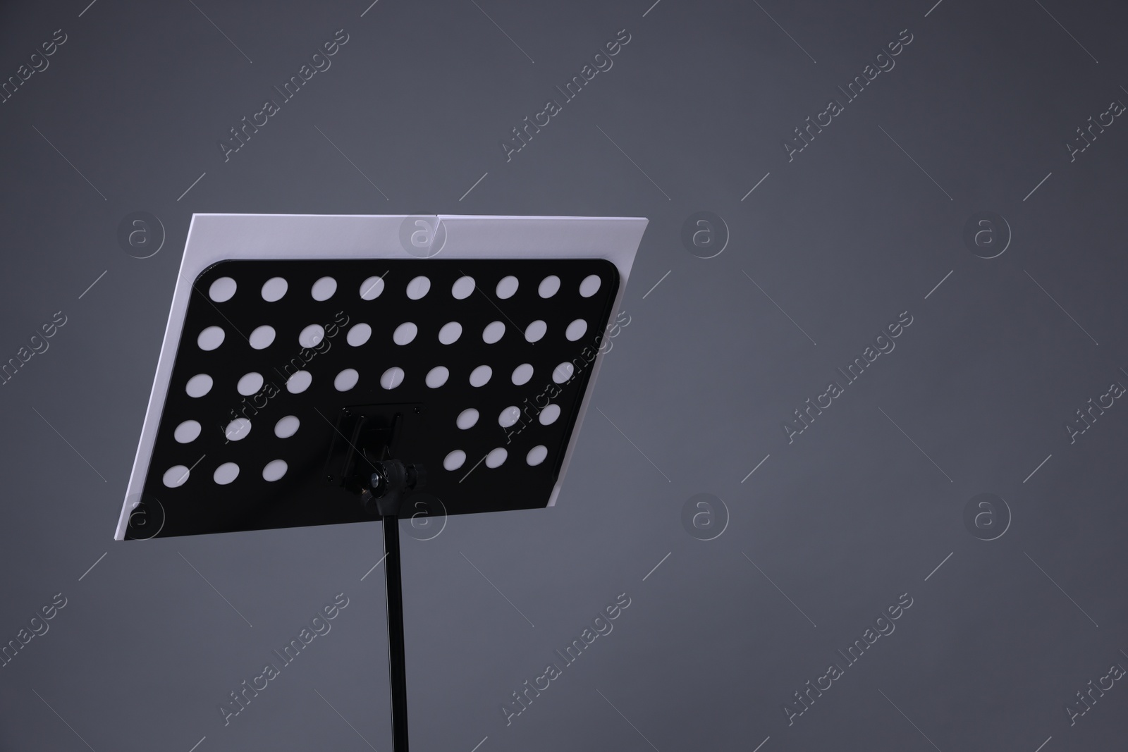 Note stand with music sheets on grey background, space for text Photo of Note stand with music sheets on grey background, space for text