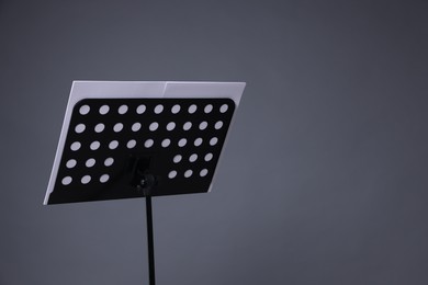Photo of Note stand with music sheets on grey background, space for text