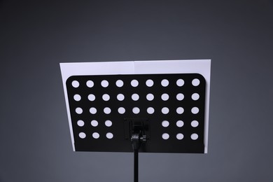 Photo of Note stand with music sheets on grey background