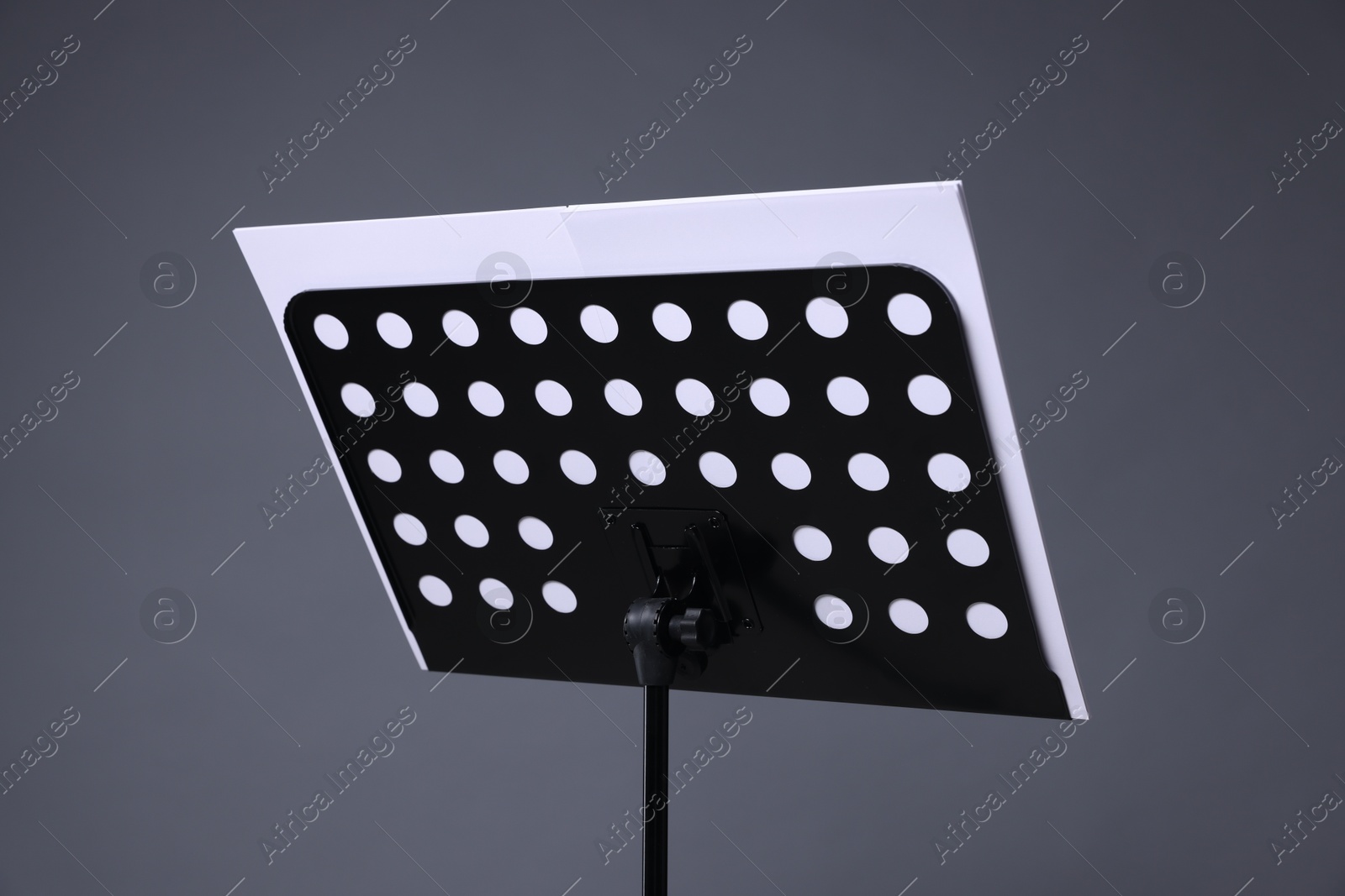 Note stand with music sheets on grey background, closeup Photo of Note stand with music sheets on grey background, closeup