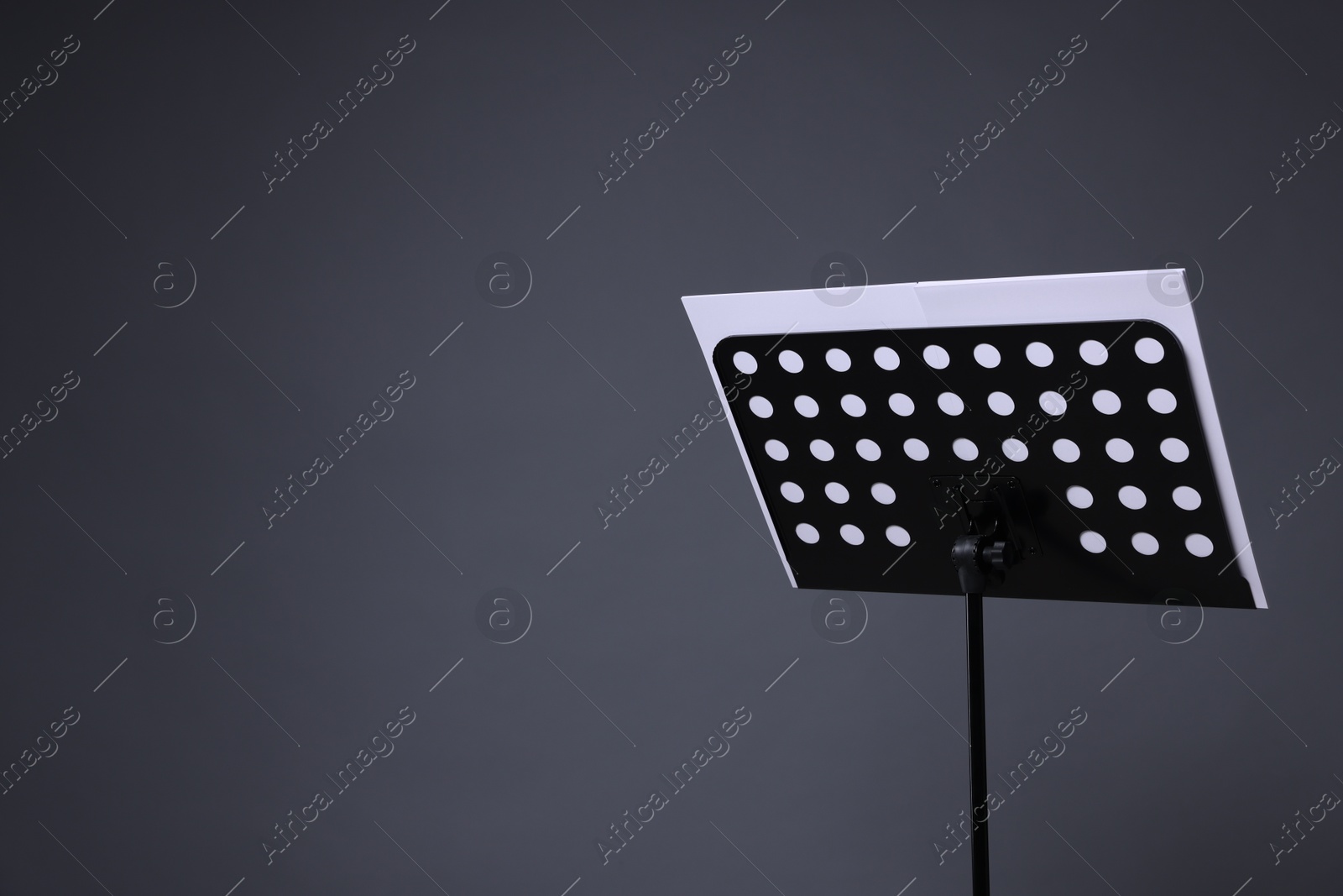 Note stand with music sheets on grey background, space for text Photo of Note stand with music sheets on grey background, space for text