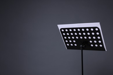 Photo of Note stand with music sheets on grey background, space for text