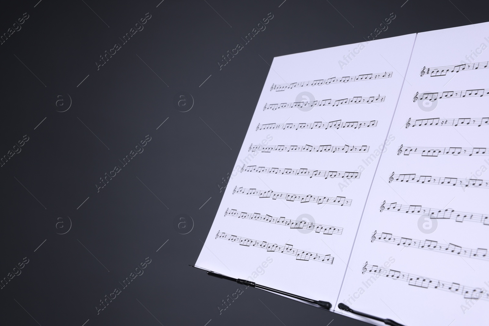 Note stand with music sheets on grey background, closeup. Space for text Photo of Note stand with music sheets on grey background, closeup. Space for text