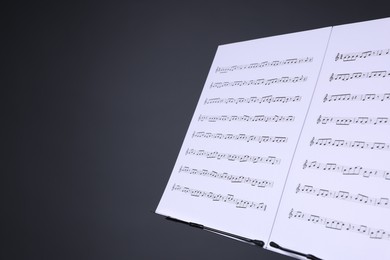 Photo of Note stand with music sheets on grey background, closeup. Space for text