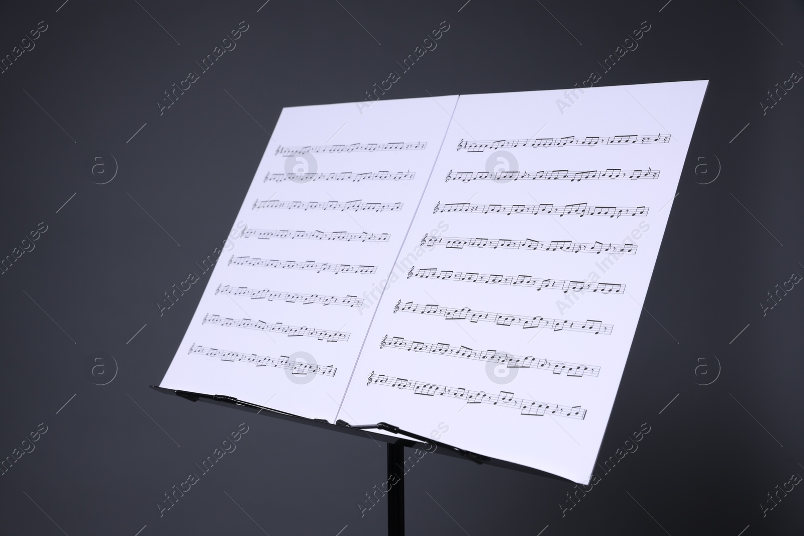 Note stand with music sheets on grey background, closeup Photo of Note stand with music sheets on grey background, closeup