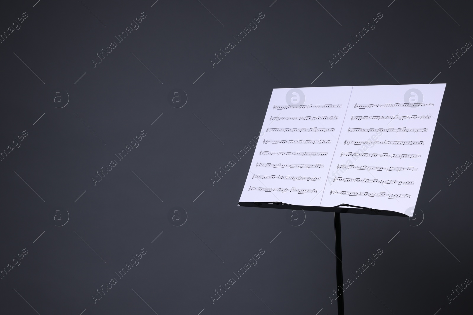 Note stand with music sheets on grey background, space for text Photo of Note stand with music sheets on grey background, space for text