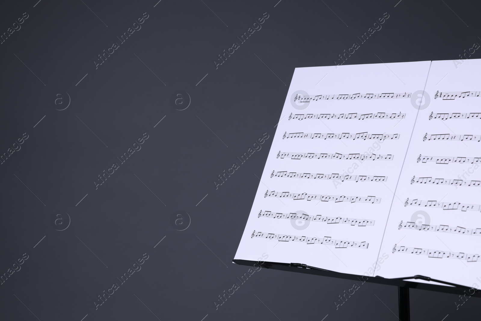 Note stand with music sheets on grey background, closeup. Space for text Photo of Note stand with music sheets on grey background, closeup. Space for text