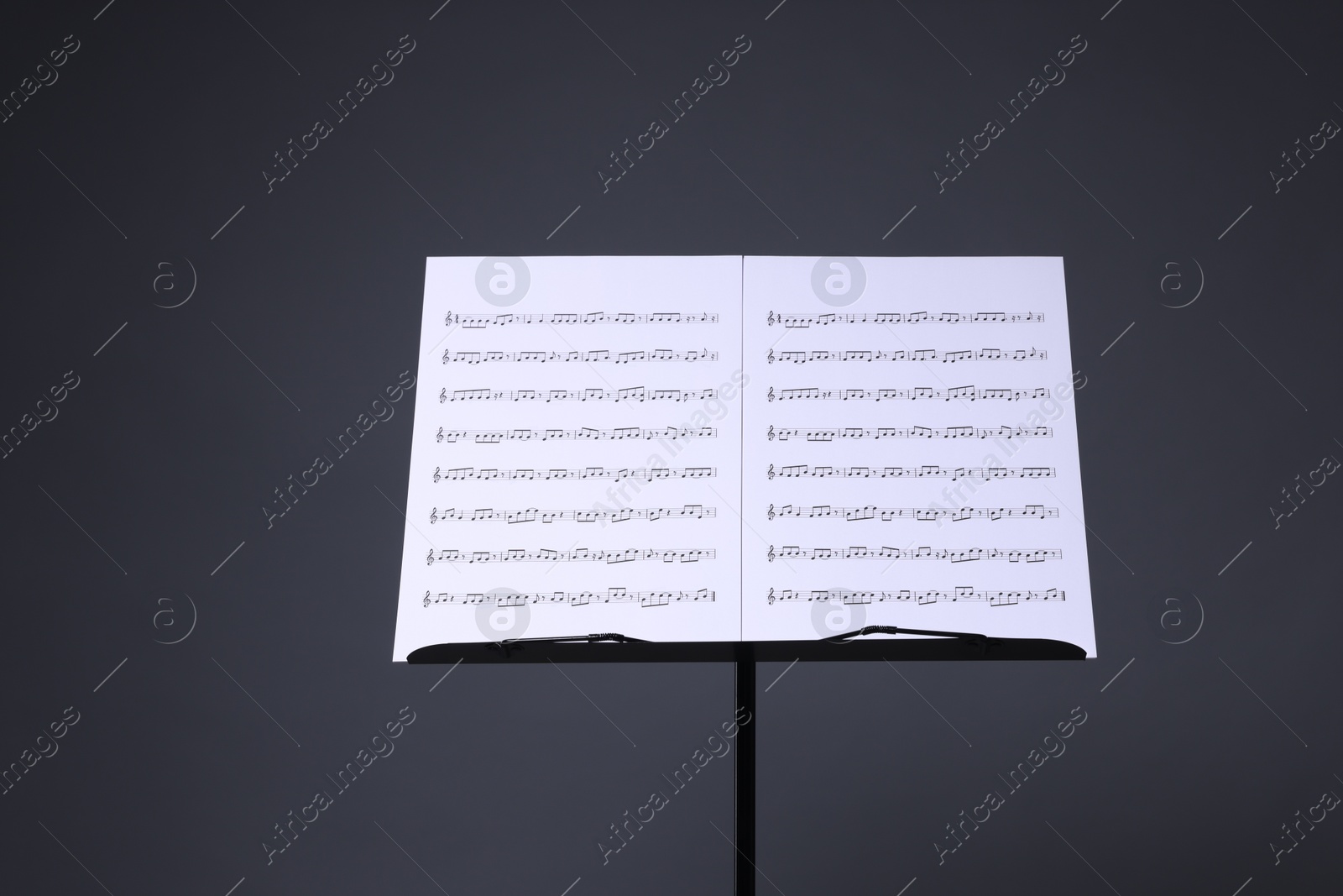Note stand with music sheets on grey background Photo of Note stand with music sheets on grey background