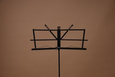 Photo of One empty note stand on dark beige background