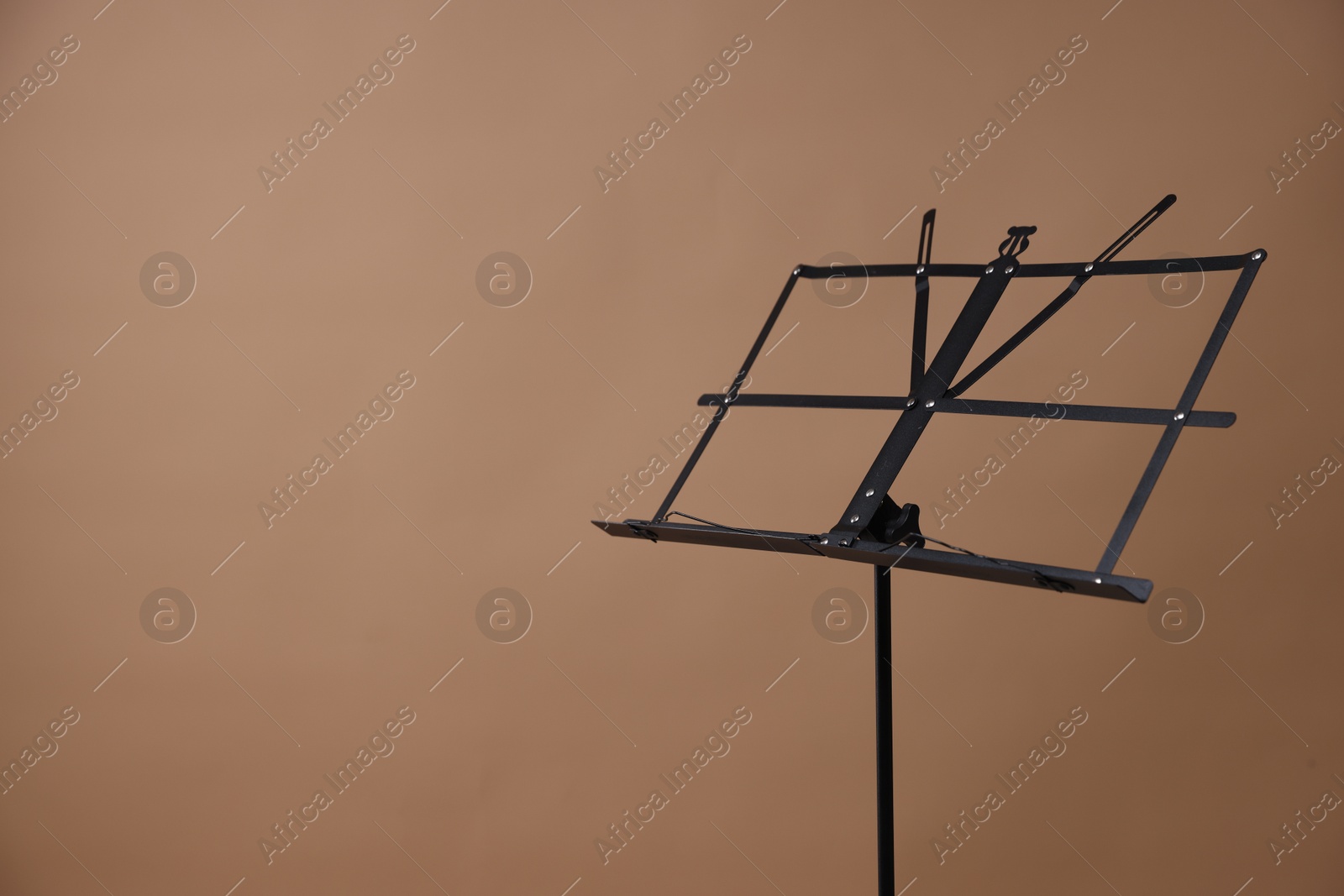 One empty note stand on dark beige background, space for text Photo of One empty note stand on dark beige background, space for text