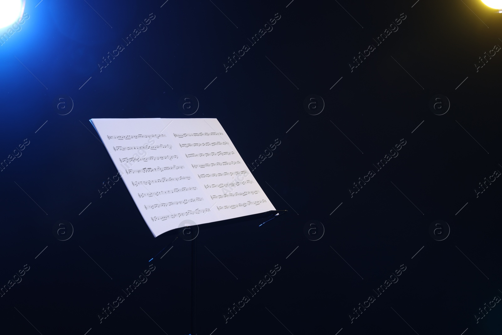 Stand with music sheets on dark background, space for text Photo of Stand with music sheets on dark background, space for text