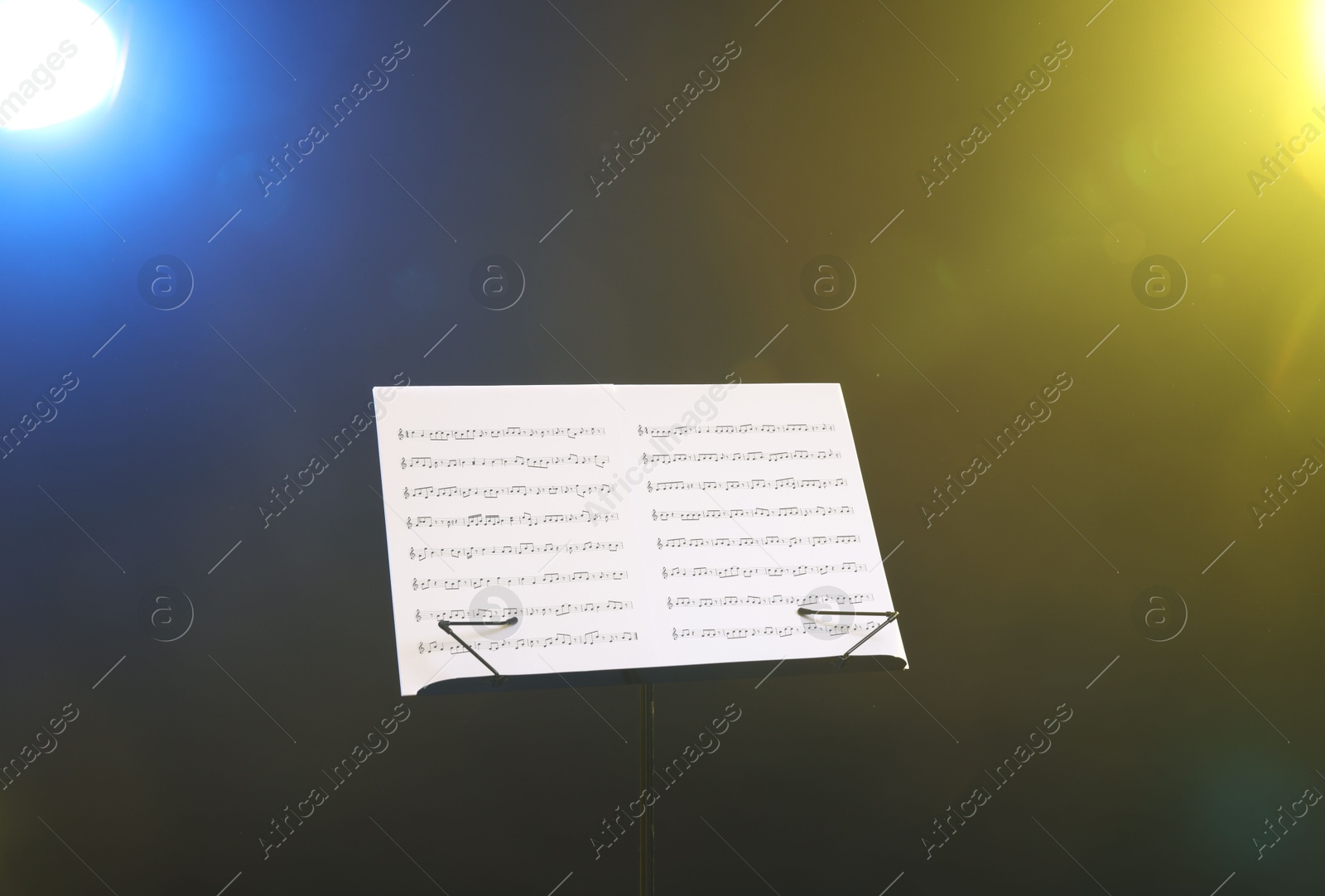 Stand with music sheets on dark background Photo of Stand with music sheets on dark background