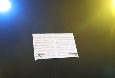 Photo of Stand with music sheets on dark background