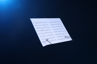 Photo of Stand with music sheets on dark blue gradient background