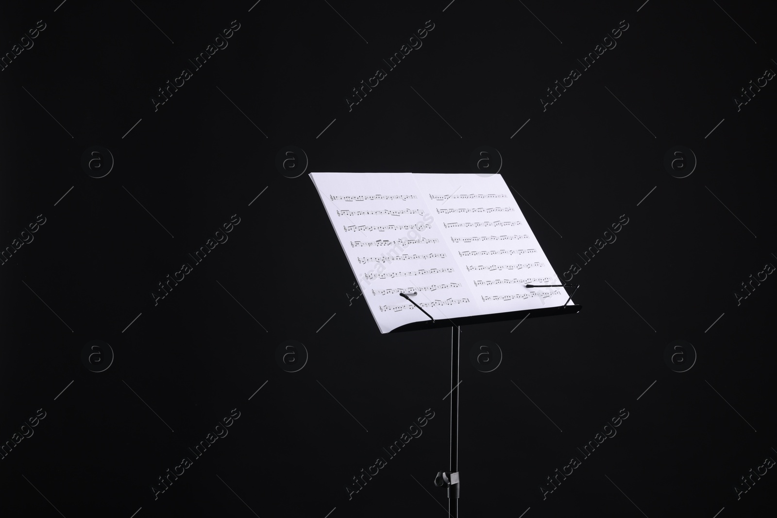 Stand with music sheets on black background, space for text Photo of Stand with music sheets on black background, space for text