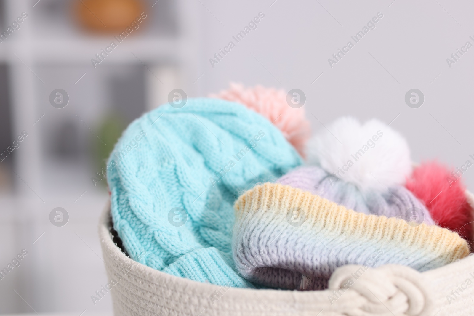 Different wool hats in basket indoors, closeup Photo of Different wool hats in basket indoors, closeup