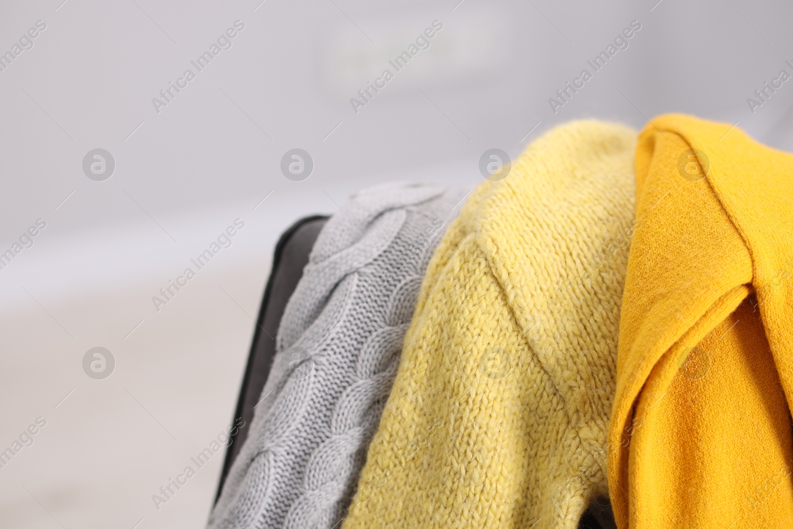 Color wool sweaters on light background, closeup Photo of Color wool sweaters on light background, closeup