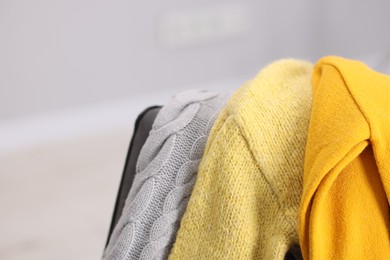 Photo of Color wool sweaters on light background, closeup